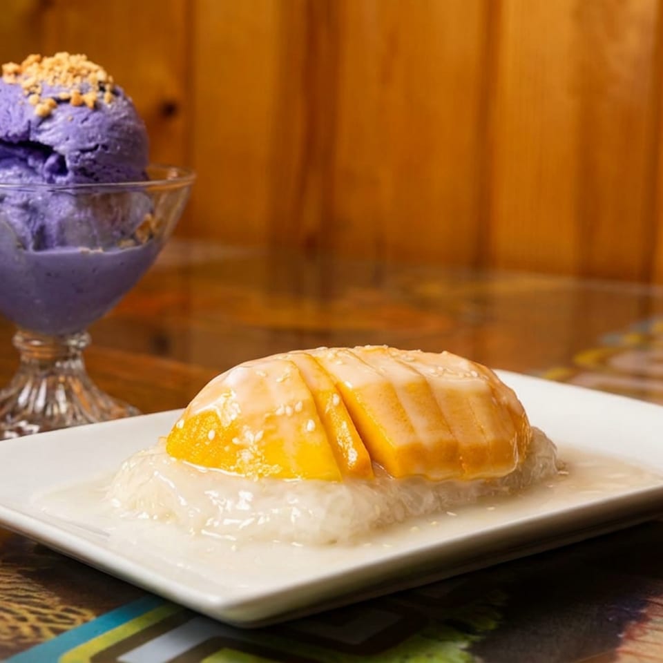 Mango sticky rice with sauce and sesame seeds next to purple ube ice cream with nuts.